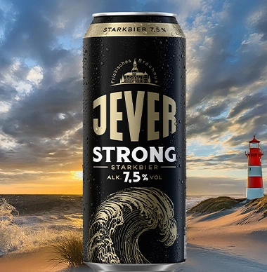 Eine Jever Strong Dose steht im Vordergrund vor einem Strand mit Leuchtturm, bei Sonnenuntergang.