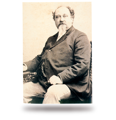 Ein Mann mittleren Alters mit Vollbart sitzt auf einem Stuhl.