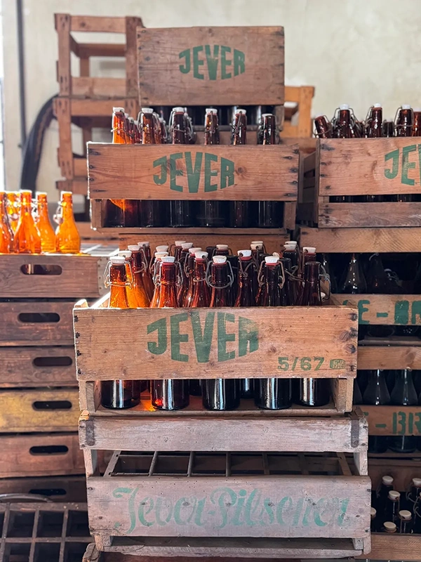 Verschiedene Bierflaschen sind in mehreren hölzernen Kisten gestapelt.