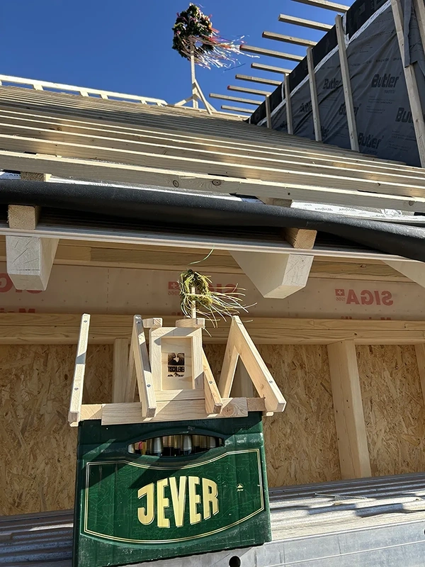 Auf dem Dach eines Holzhauses befindet sich ein Bamstrauß und eine Holzkiste.