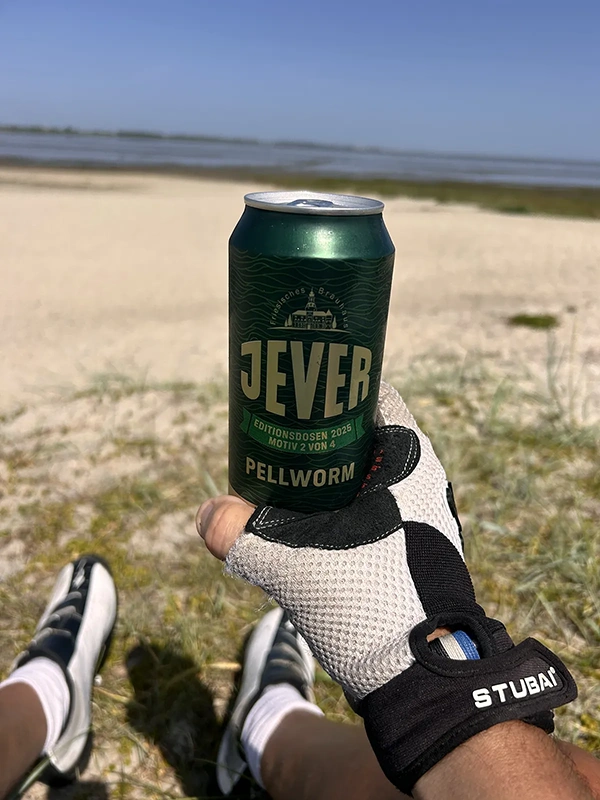 Bierdose mit der Aufschrift Jever Pellworm wird von einer Person mit Fahrradhandschuh gehalten.