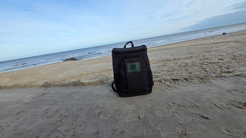 Ein Jever-Rucksack steht auf dem Sand eines Strandes.