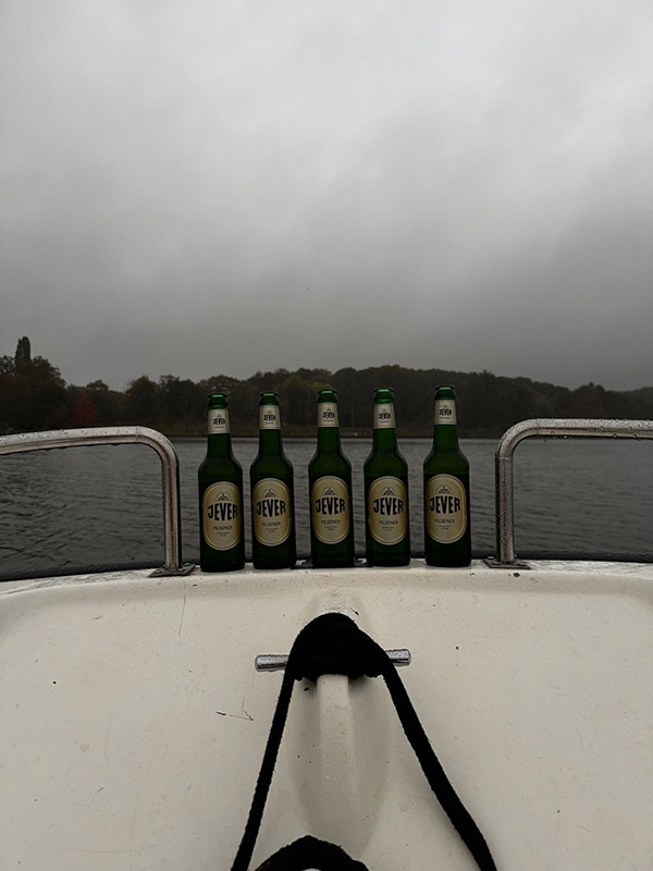 Mehrere Jever-Bierflaschen stehen auf dem Rand eines Boots.