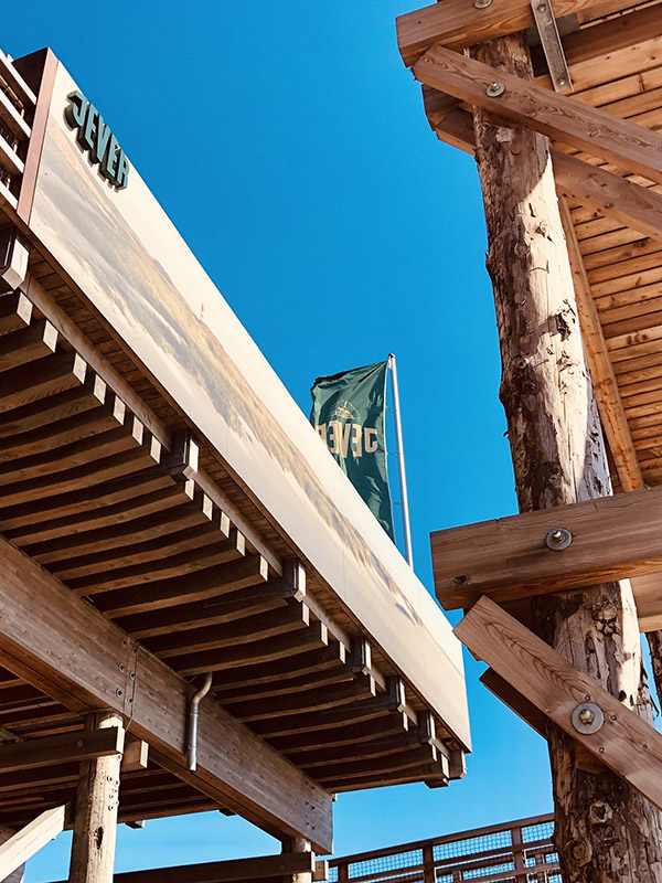 An dem Dach eines Gebäudes hängt ein Jever-Schriftzug. Im Hintergrund weht eine Jever-Fahne.