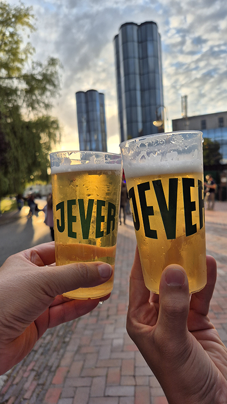 Zwei Hände halten Bierbecher mit 