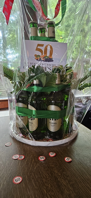 Geschenk aus Jever Flaschen zum 50. Geburtstag, mit Folie und Glückwunschkarte dekoriert.