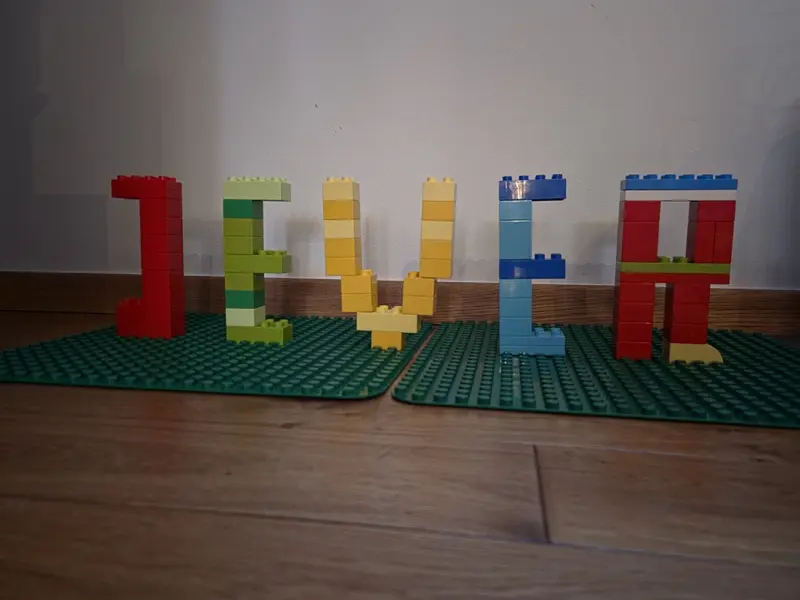 Der Schriftzug Jever ist aus bunten Bausteinen zusammengesetzt und steht auf Bauplatten.
