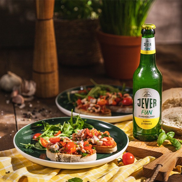 Ein rustikaler Holztisch ist mit leckeren Bruschettas und einem Getränk dekoriert. Die Atmosphäre wirkt einladend und warm.