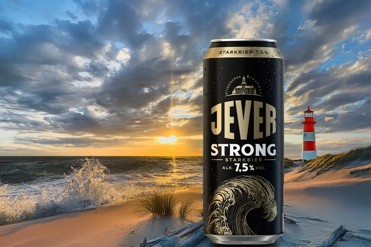 Schwarze Getränkedose mit goldener Aufschrift Jever Strong. Im Hintergrund Meer mit Sonnenuntergang und rotem Leuchtturm.